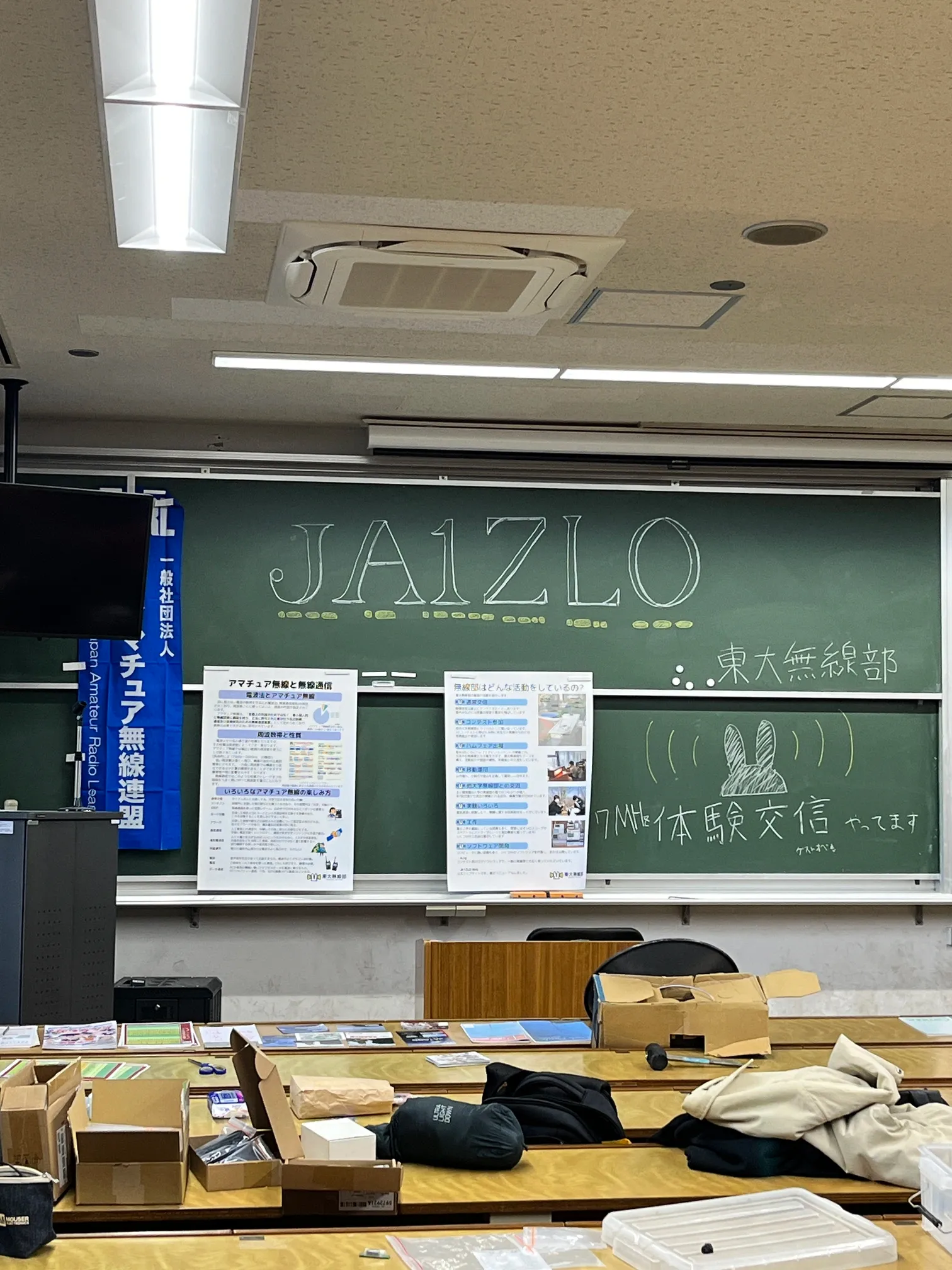 教室前方、黒板。無線部の活動紹介ポスターが貼られている